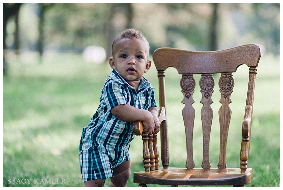 Boy standing by chair - 6 Months