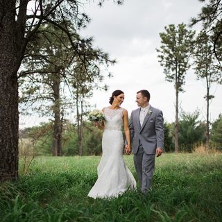 Laughing at Pioneers Park with her groom in a lace dress