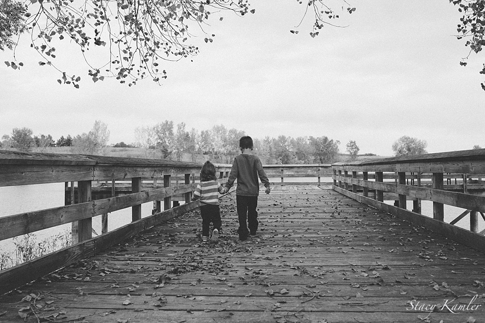 Brother and Sister walking on pier at lake