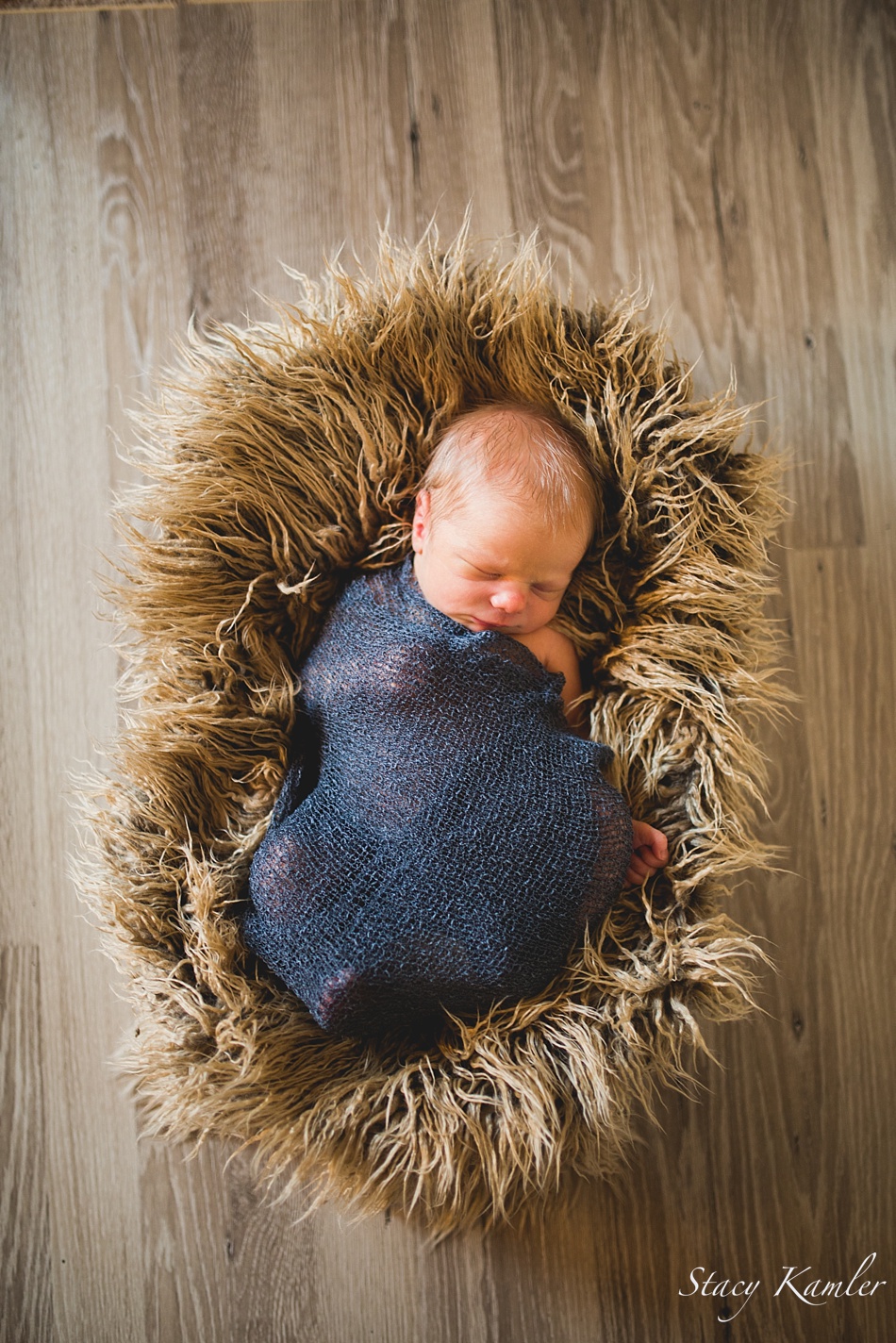 Sleepy Newborn in a basket with brown fake fur