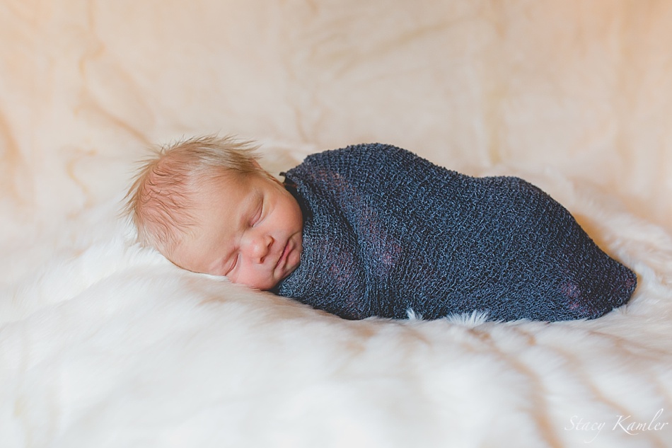 Newborn baby boy in a blue stretch wrap