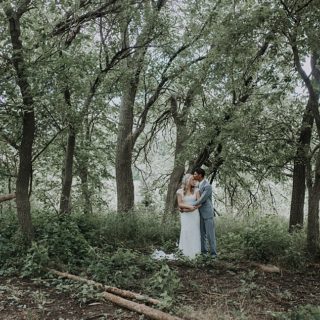 Bride and Groom in green grass and wooded area for portraits