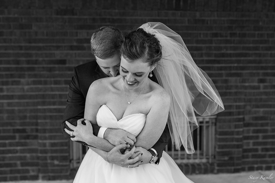 Black and white photo of bride and groom hugging