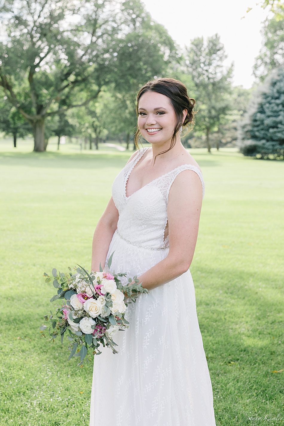 Bride wearing a tank lace dress with Pink and Green flowers